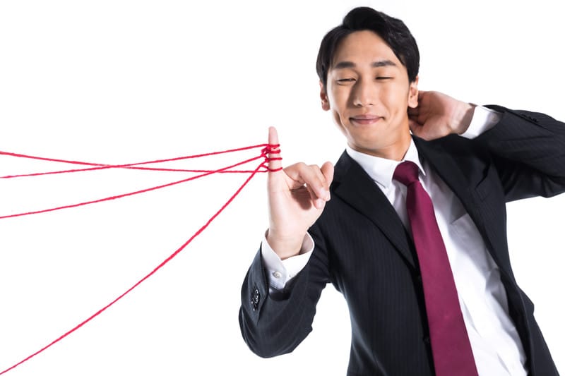 赤い糸をたくさん見つめている男性